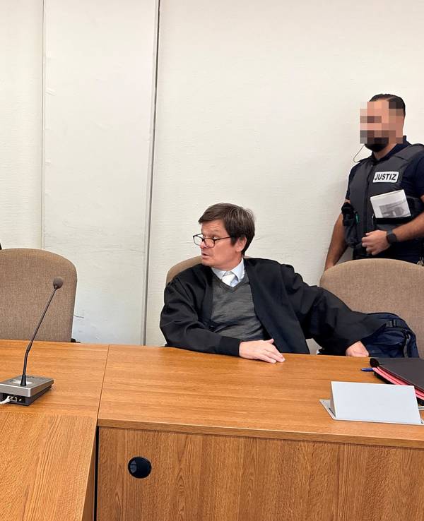 Landgericht Köln: Der Beschuldigte begrüßt Dolmetscher Bahadir Aksungur. Daneben Verteidiger Christian Kemperdick.
