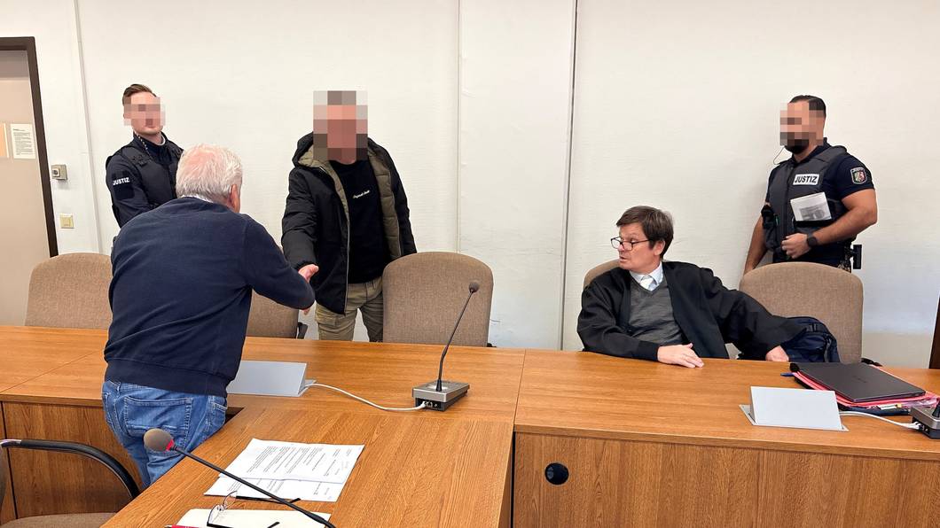 Landgericht Köln: Der Beschuldigte begrüßt Dolmetscher Bahadir Aksungur. Daneben Verteidiger Christian Kemperdick.