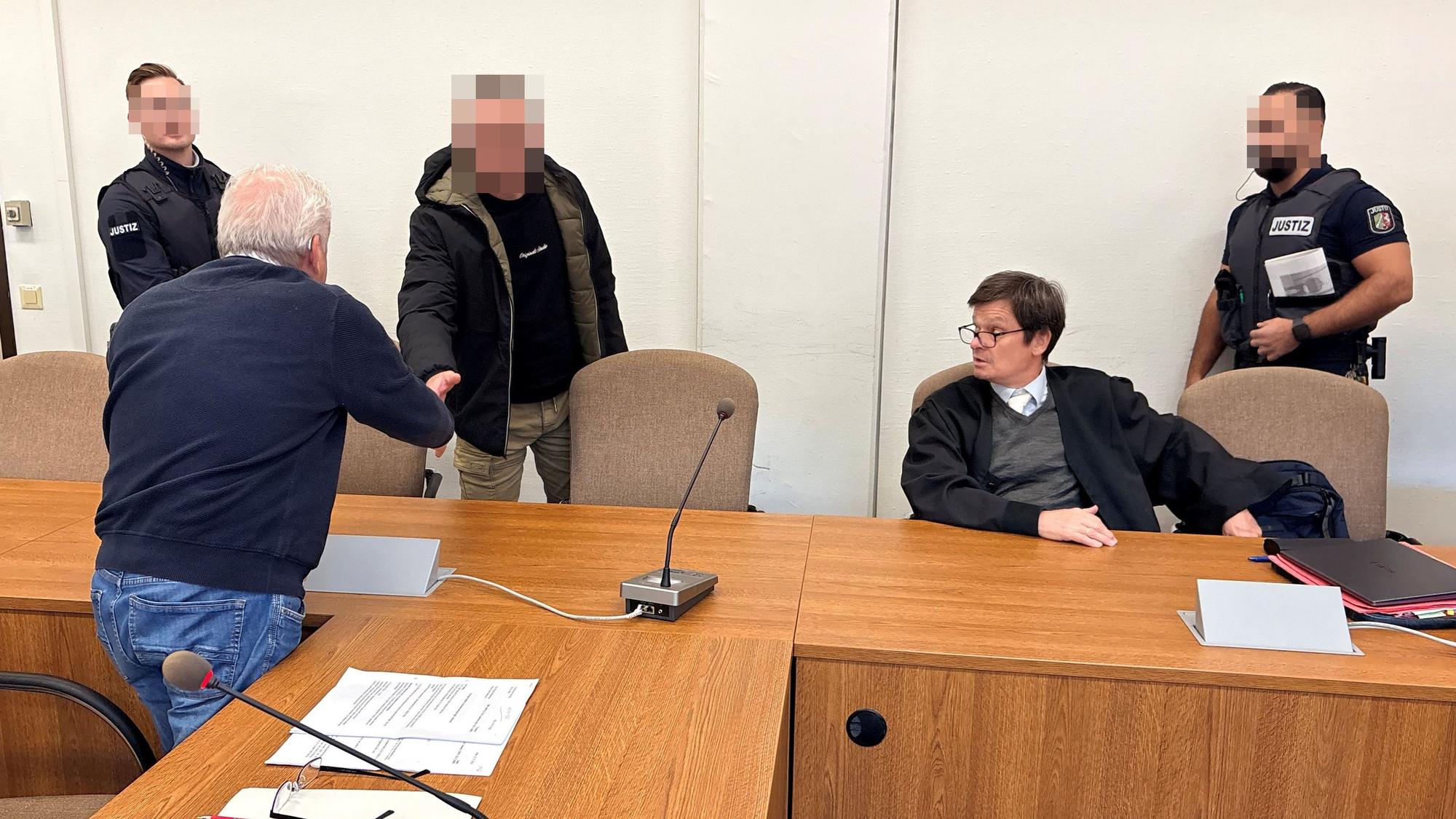 Landgericht Köln: Der Beschuldigte begrüßt Dolmetscher Bahadir Aksungur. Daneben Verteidiger Christian Kemperdick.