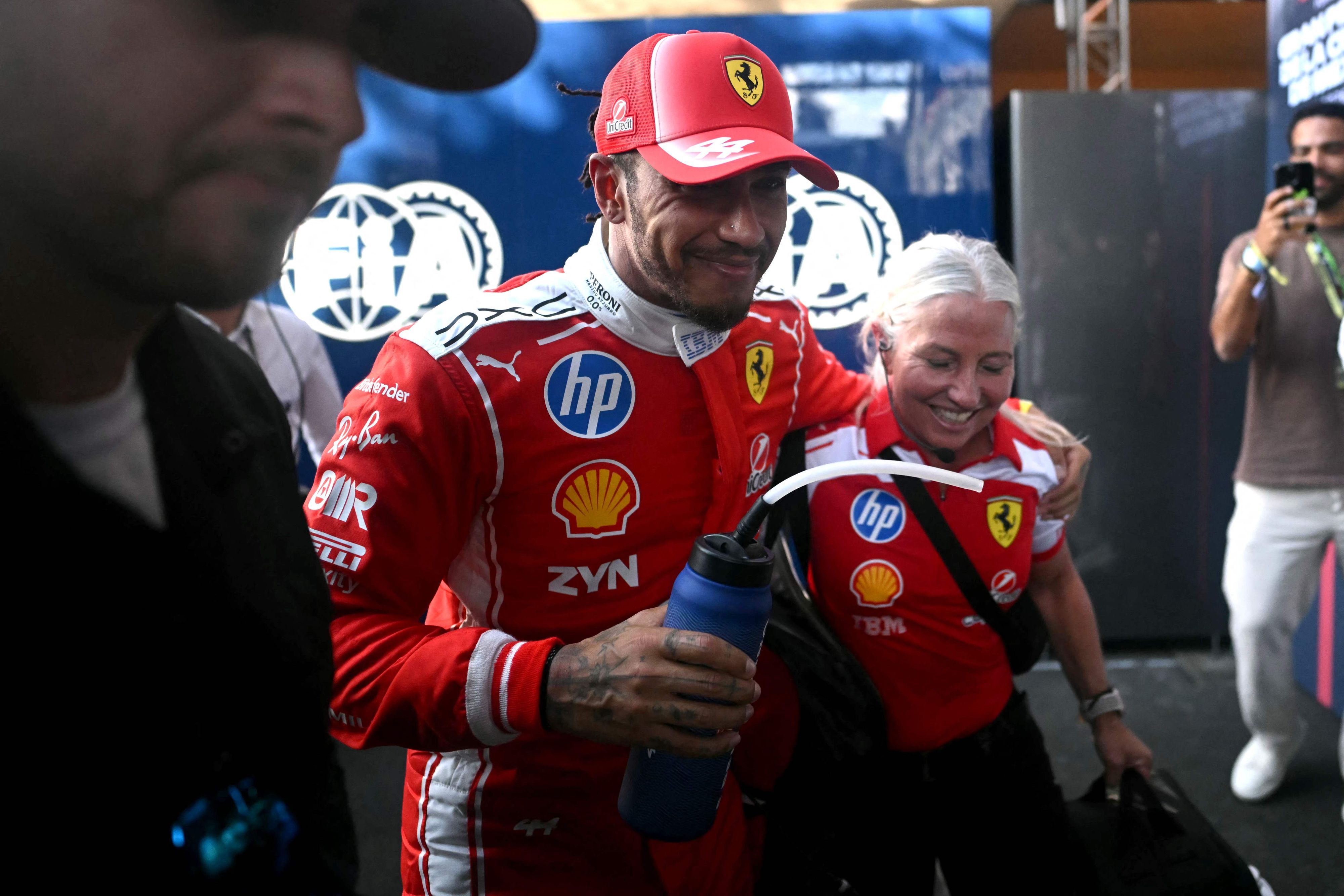 Lewis Hamilton freut sich mit einer Ferrari-Mitarbeiterin.