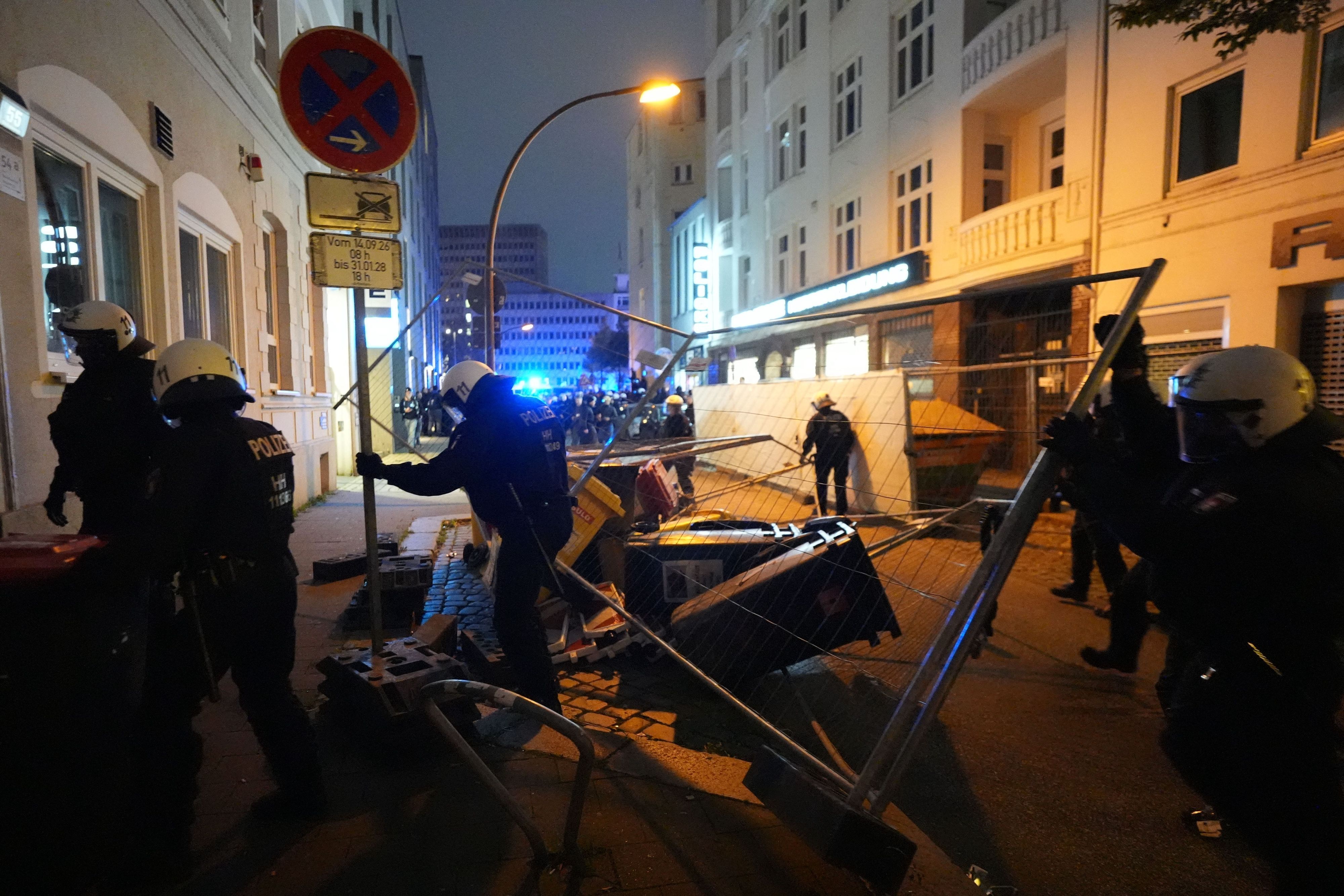 Einsatzkräfte der Polizei entfernen eine Barrikade auf einer Straße im Hamburger Stadtteil St. Georg, die am Rande der Demonstration „Gen Z regelt“ errichtet wurde.