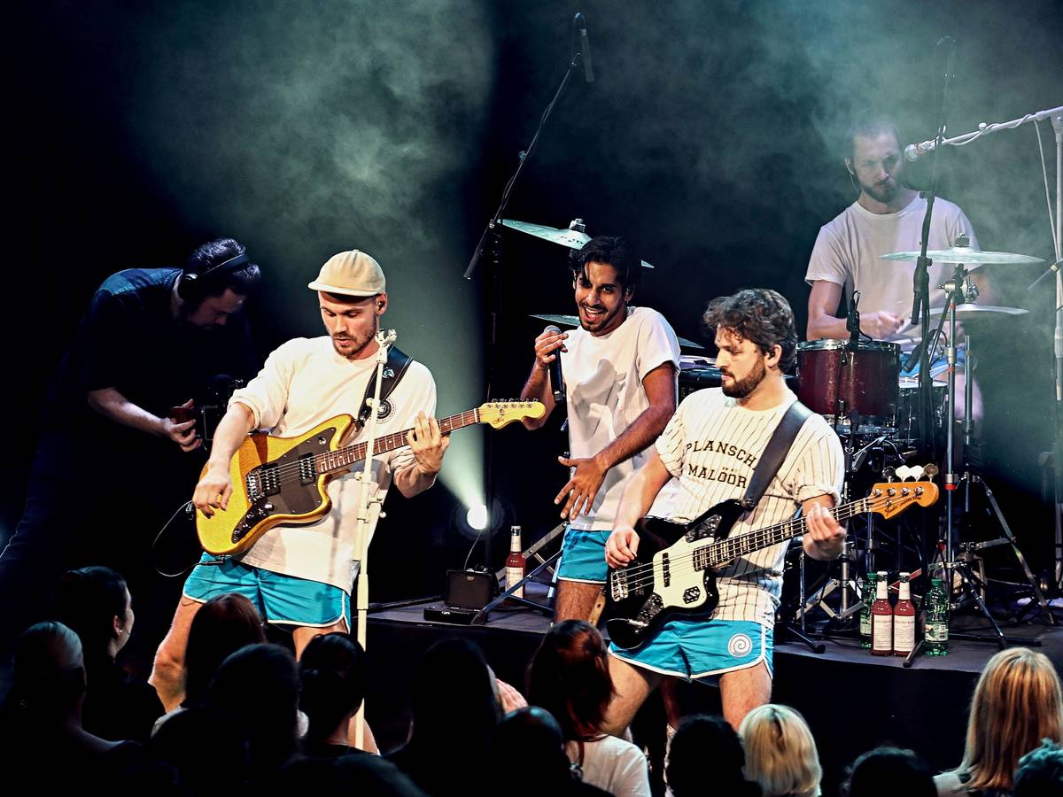 Vier Musiker spielen vor Publikum.