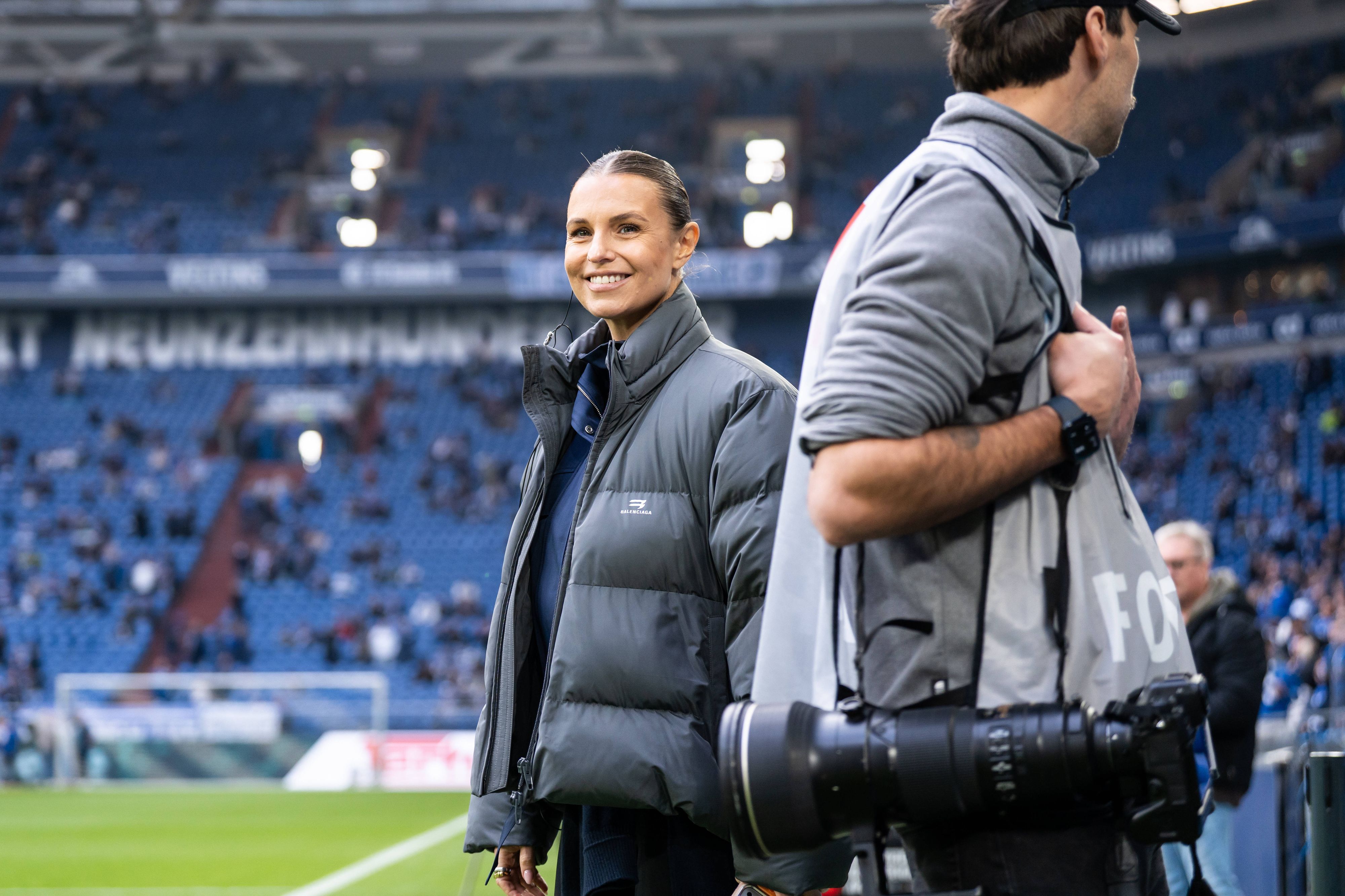 Laura Wontorra steht lächelnd im Schalker Stadion.