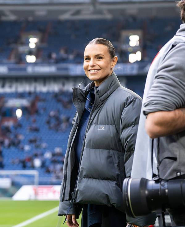 Laura Wontorra steht lächelnd im Schalker Stadion.