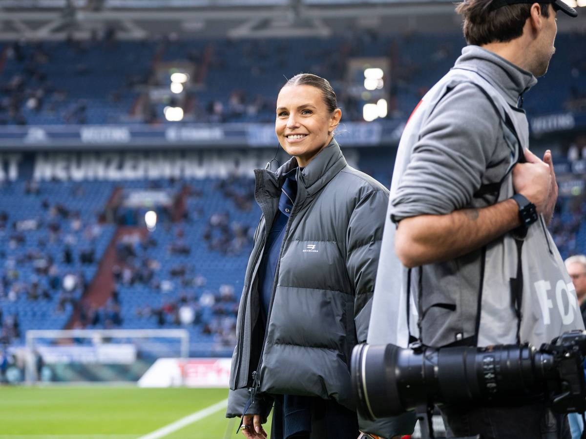 Laura Wontorra steht lächelnd im Schalker Stadion.