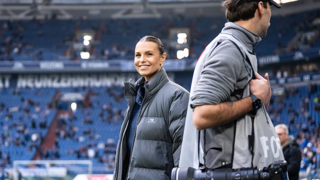 Laura Wontorra steht lächelnd im Schalker Stadion.