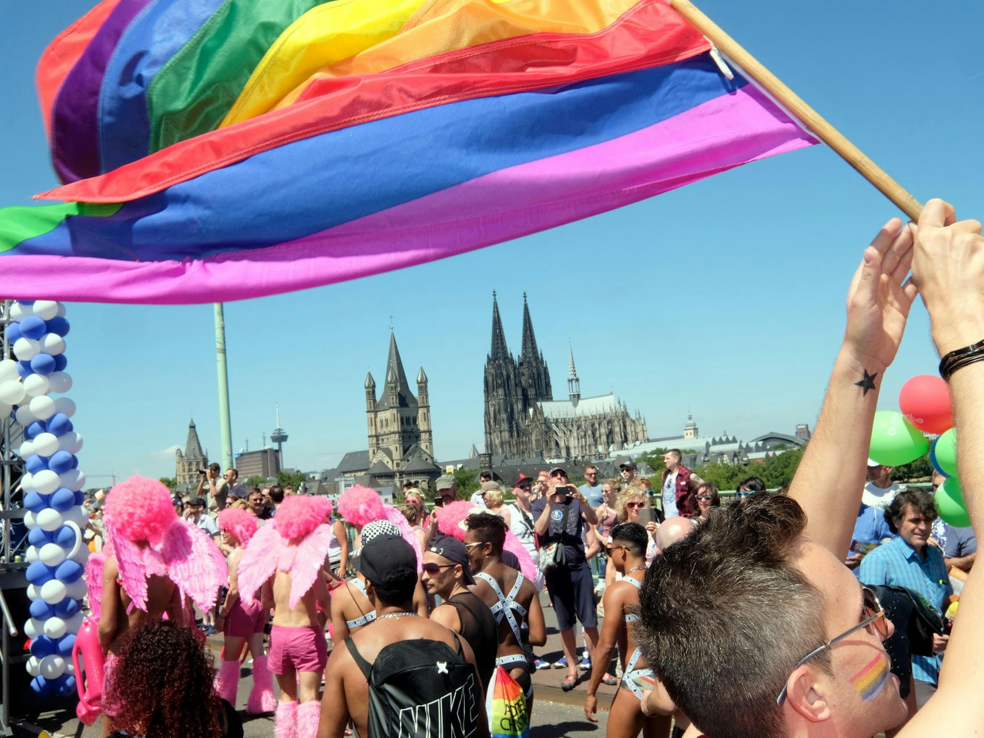 Bunt kostümierte Menschen laufen bei der CSD-Parade in Köln mit.