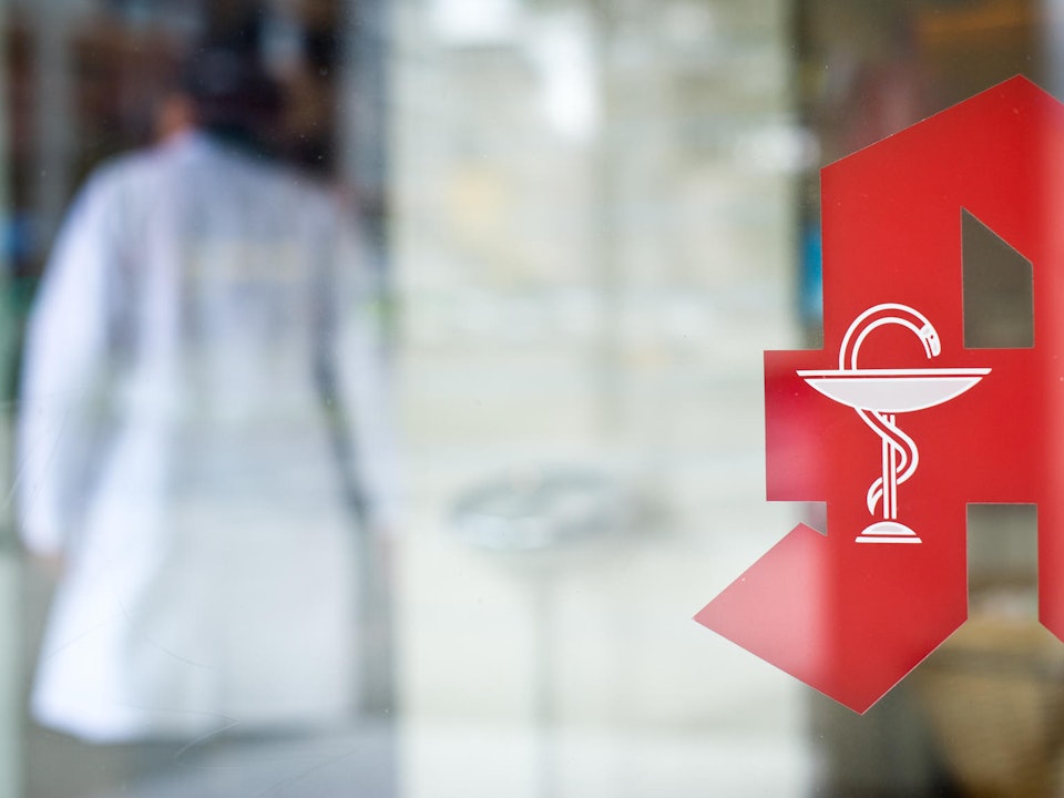 NRW: Mitarbeiter steht in einer Apotheke hinter dem Tresen.