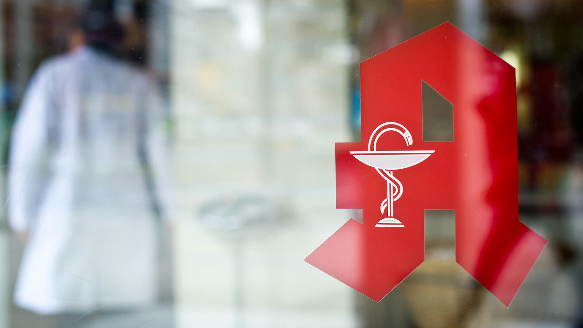 NRW: Mitarbeiter steht in einer Apotheke hinter dem Tresen.