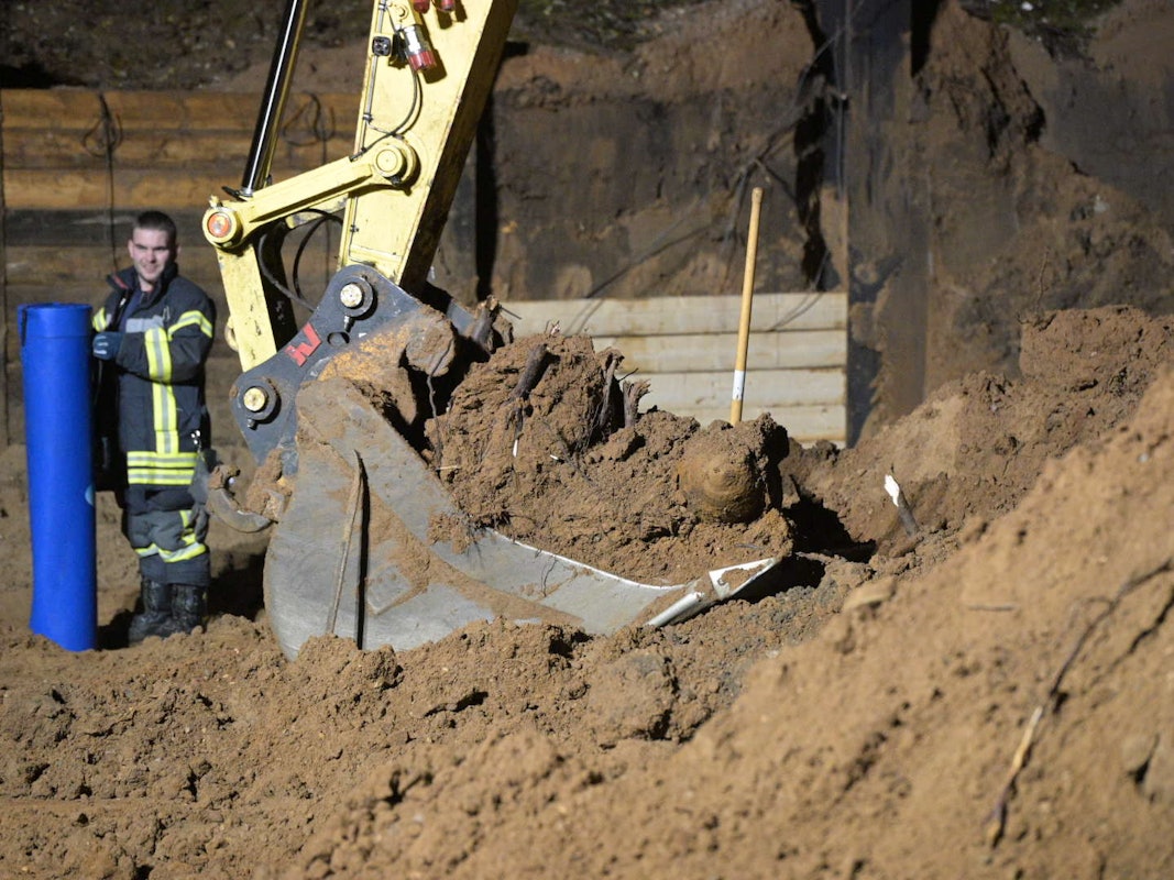 Eine Fünf-Zentner-Bombe liegt in der Schaufel eines Baggers.