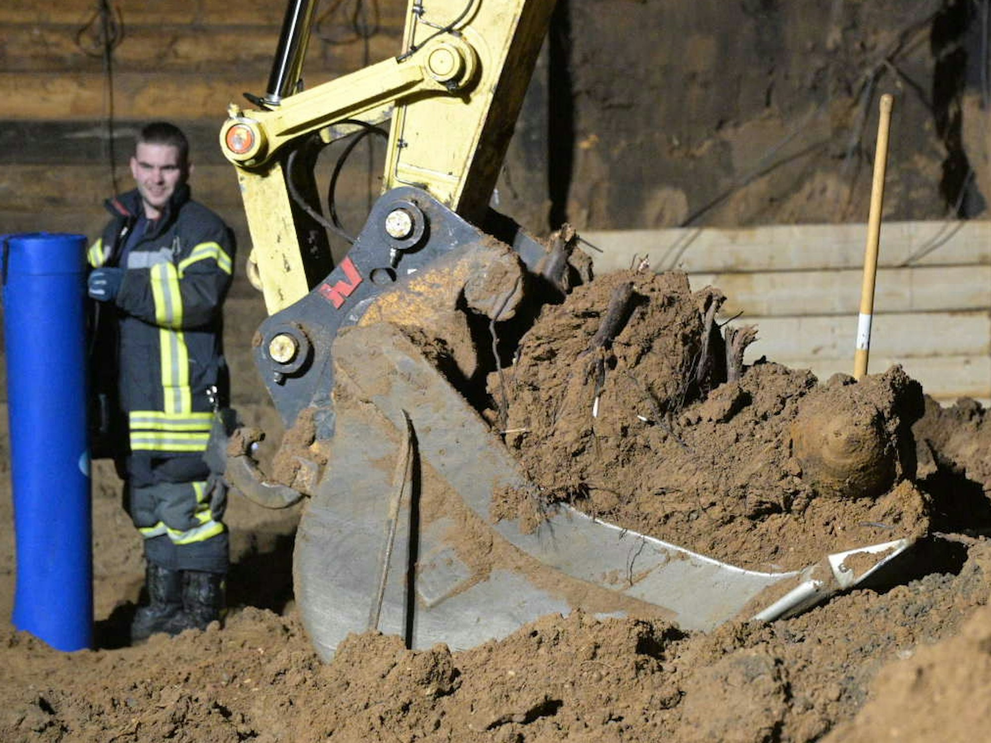 Eine Fünf-Zentner-Bombe liegt in der Schaufel eines Baggers.