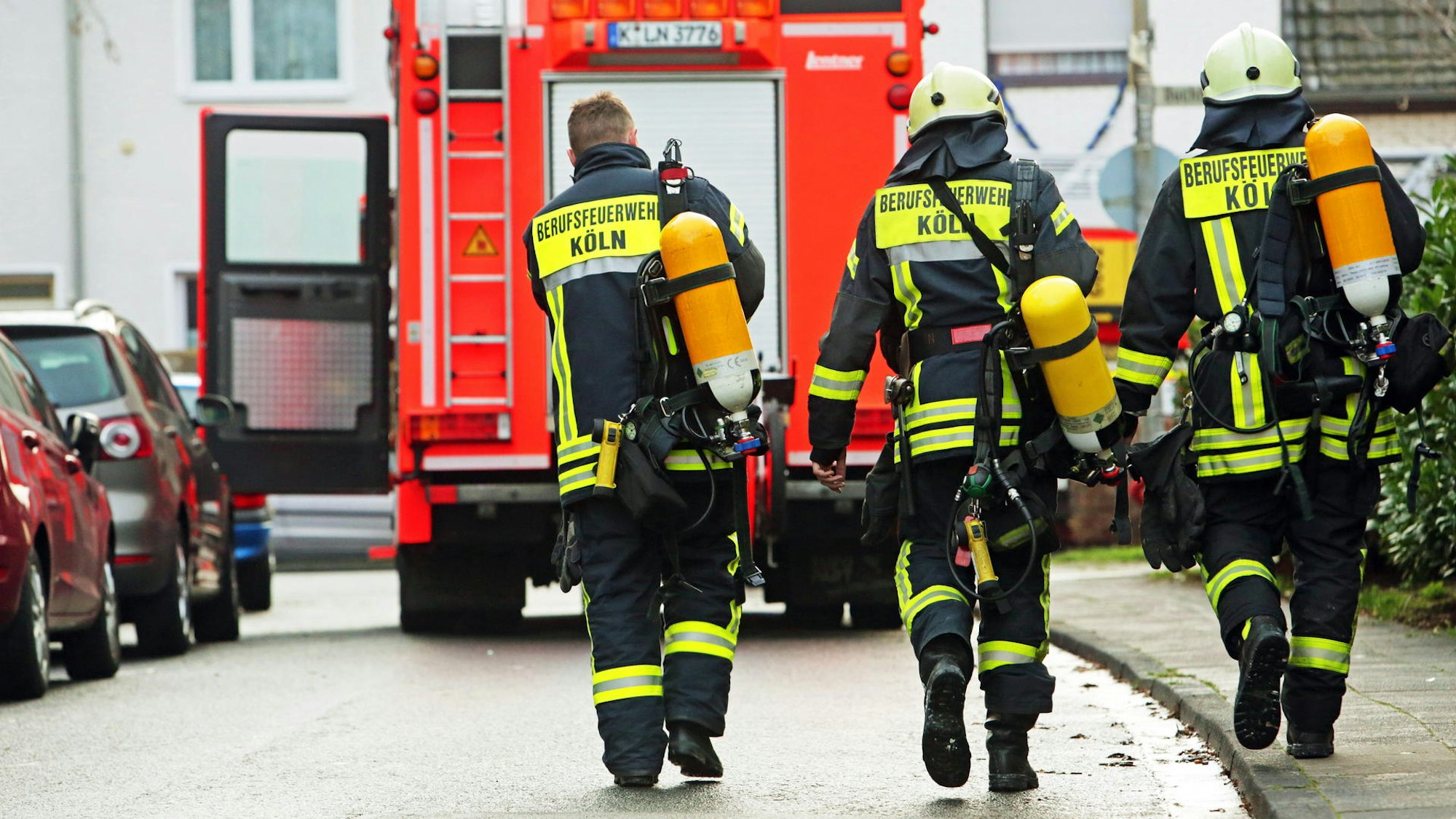 Feuerwehrmänner laufen auf ein Löschfahrzeug zu.