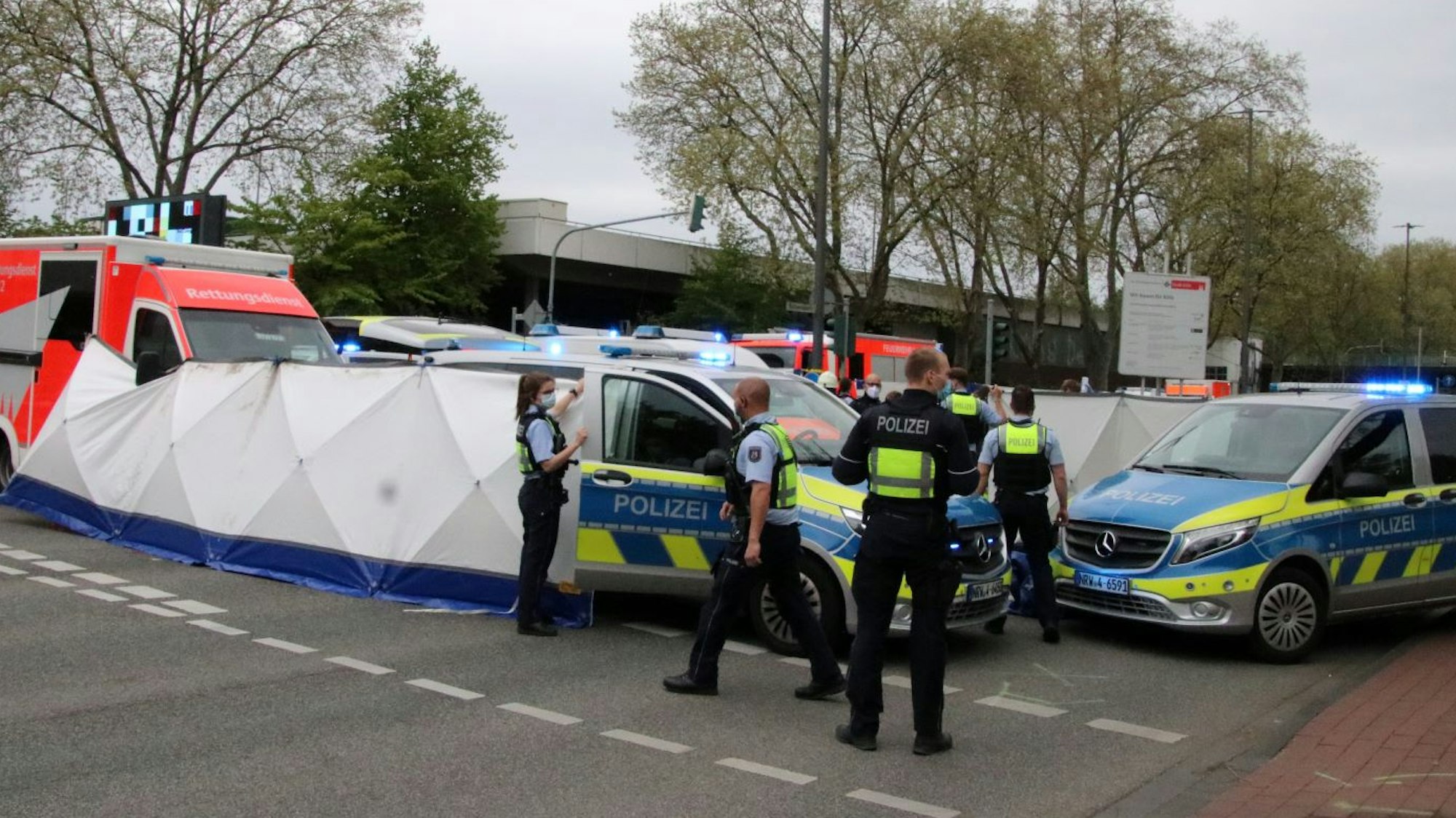 Polizisten verdecken die Unfallstelle mit einem Sichtschutz.