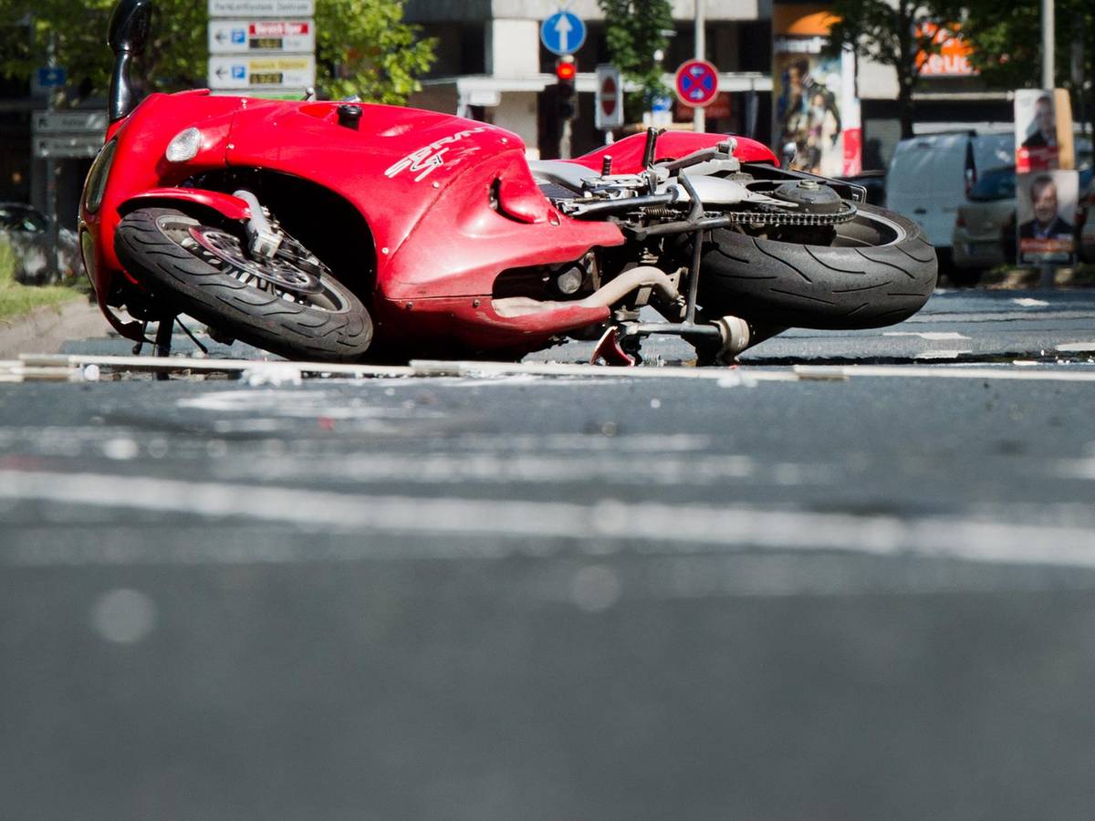 Köln. Ein rotes Motorrad liegt nach einem Unfall auf dem Boden.