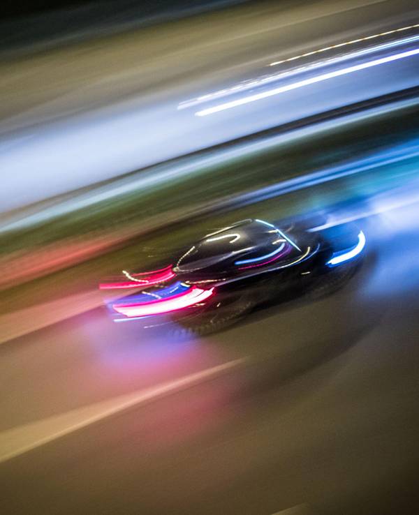 Ein Auto rast über eine Straße.
