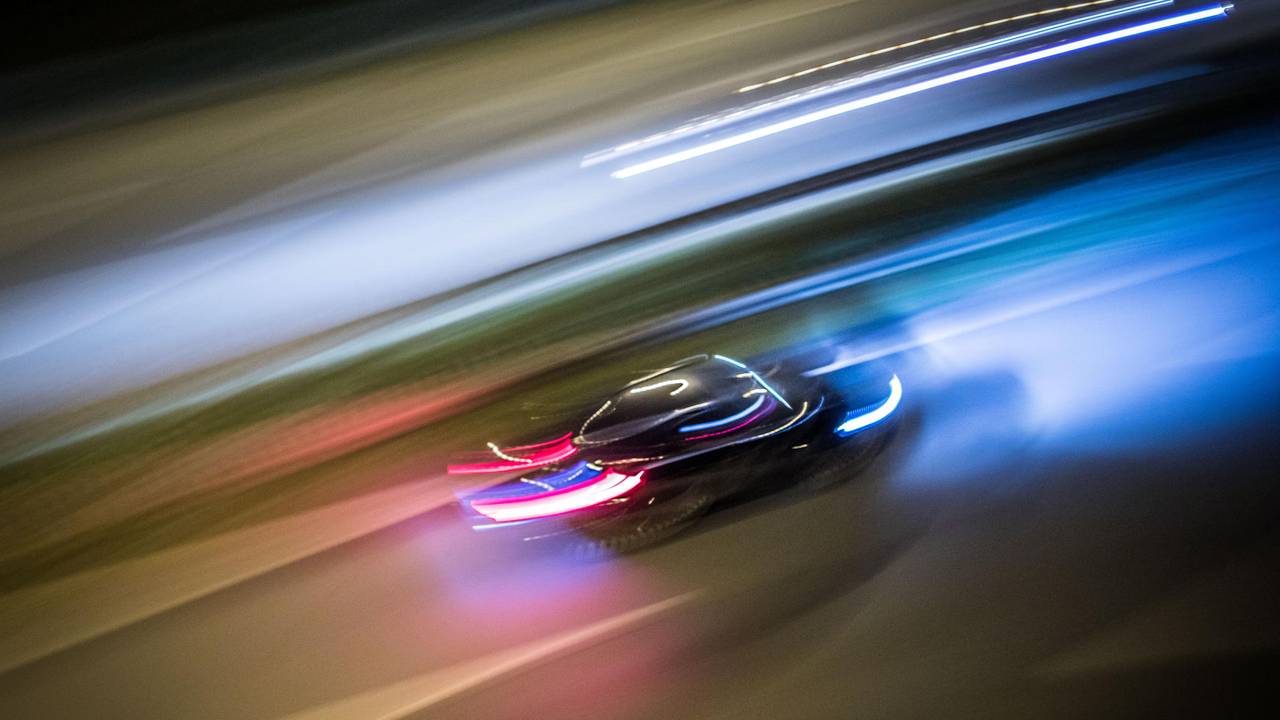 Ein Auto rast über eine Straße.
