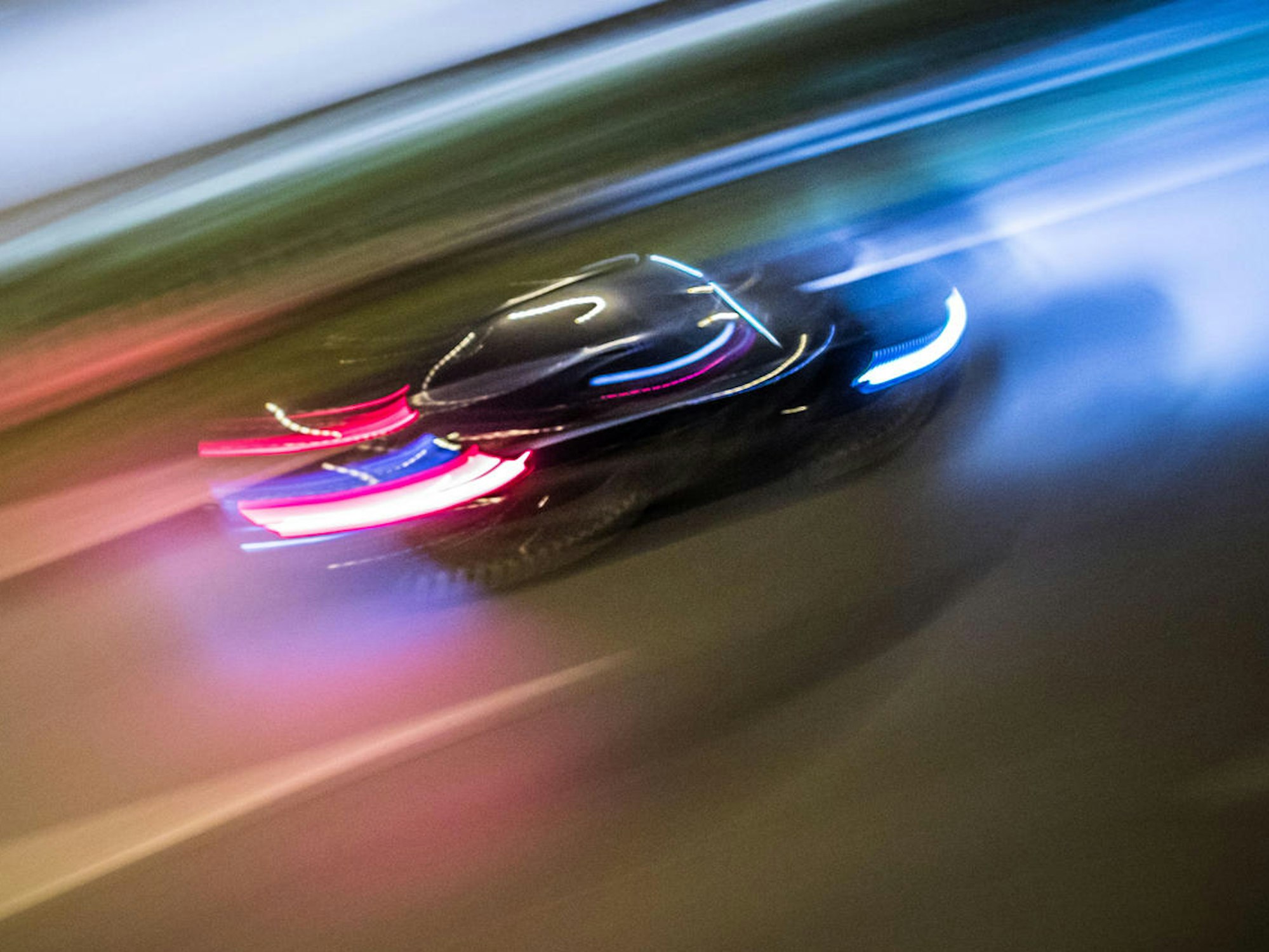 Ein Auto rast über eine Straße.