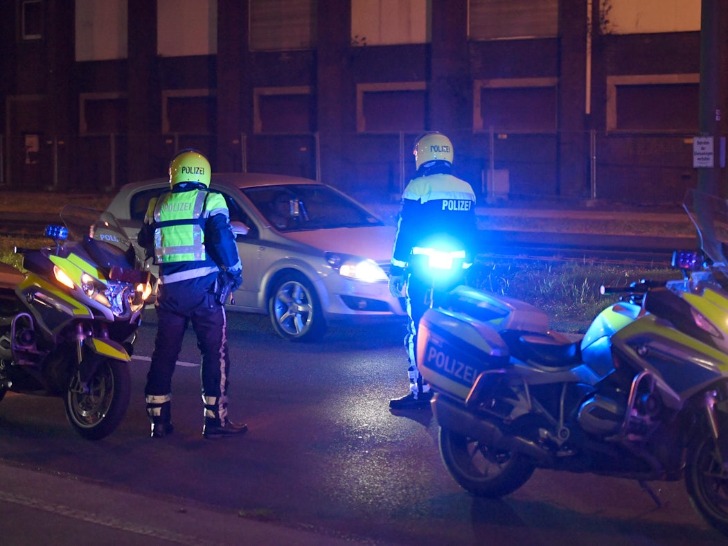 Zwei Polizisten stoppen ein Auto.