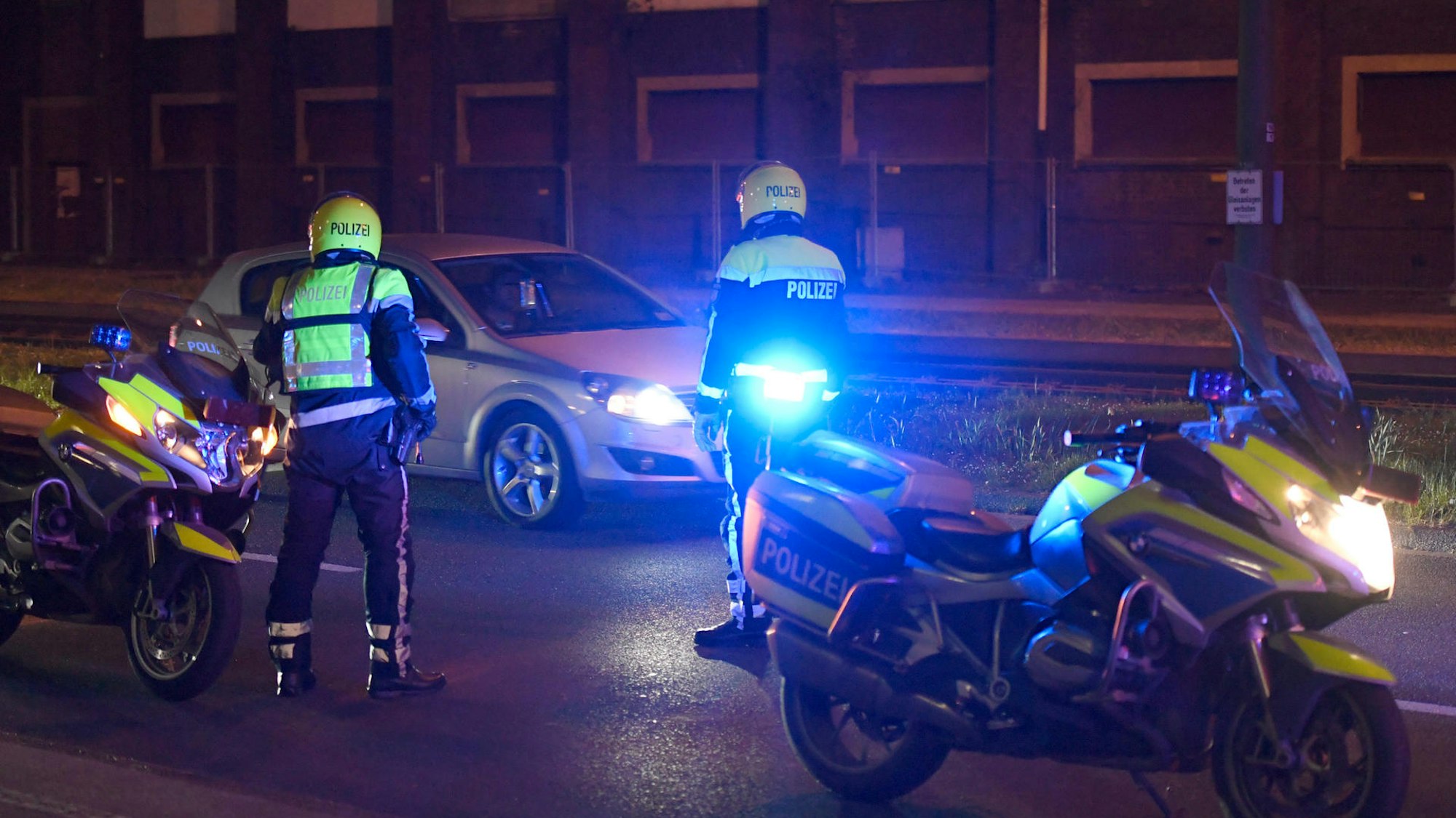 Zwei Polizisten stoppen ein Auto.