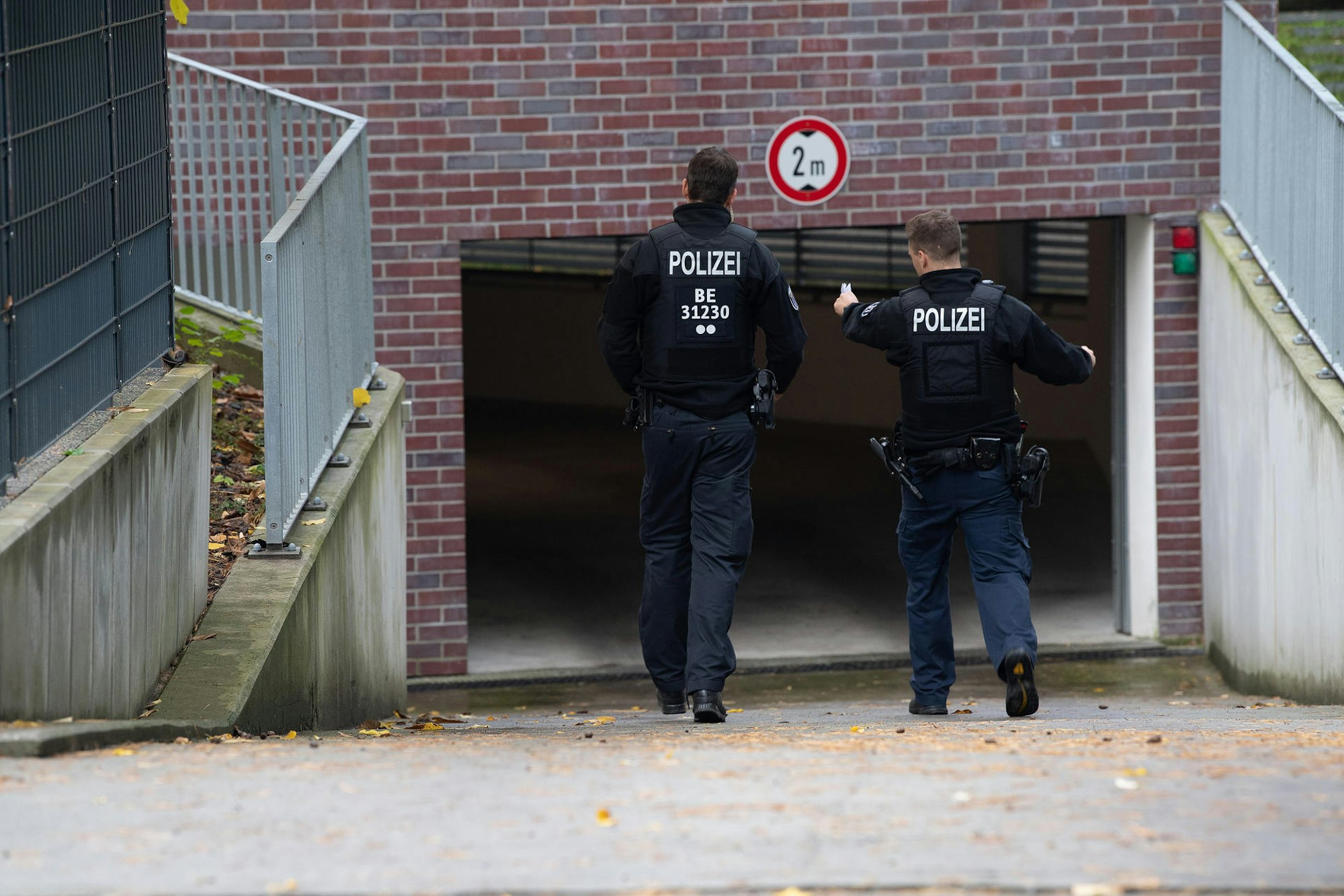 Zwei Polizisten gehen in eine Tiefgarage.