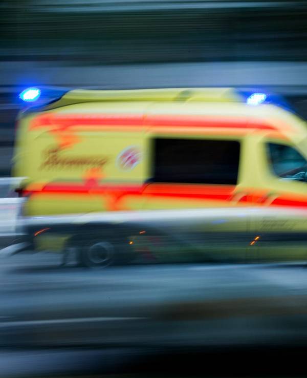 Ein Krankenwagen fährt mit Blaulicht über eine Straße.