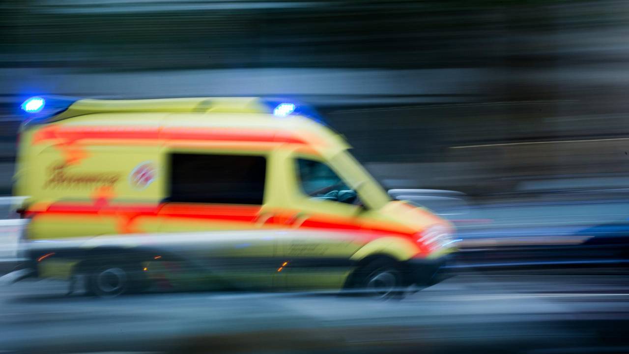 Ein Krankenwagen fährt mit Blaulicht über eine Straße.