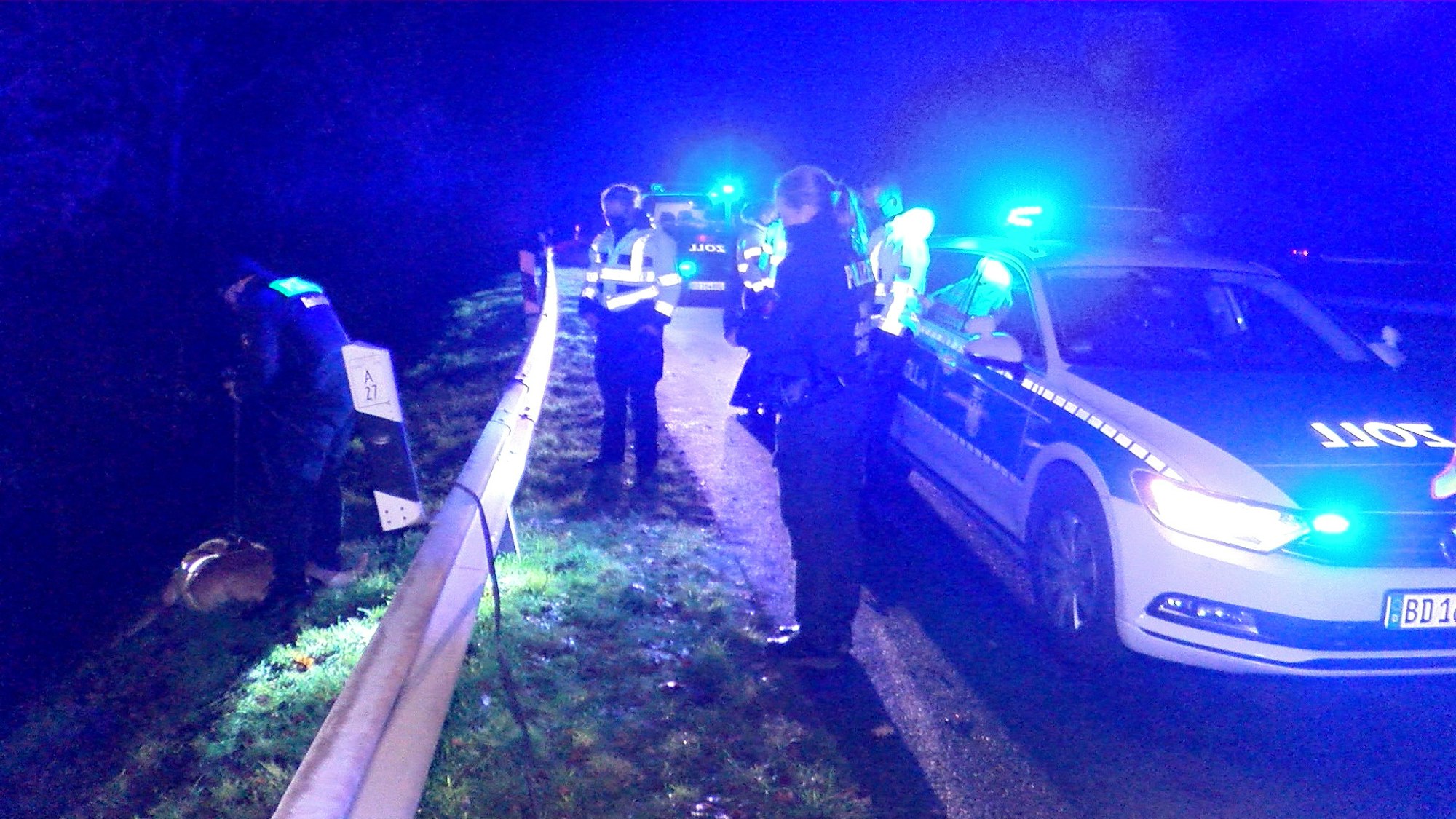 Mehrere Streifenwagen und Einsatzkräfte stehen nach einem Unfall an einer Leitplanke.