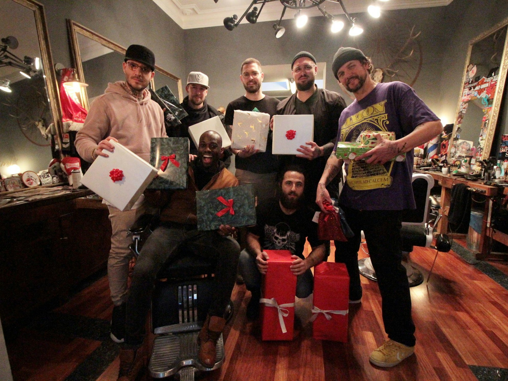 Mitarbeiter eines Friseurgeschäft posieren mit Geschenken.