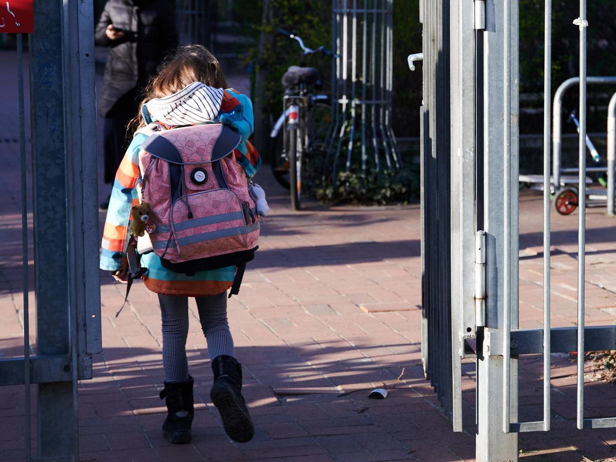 Köln: Grundschulkind betritt mit Schulranzen das Gelände.