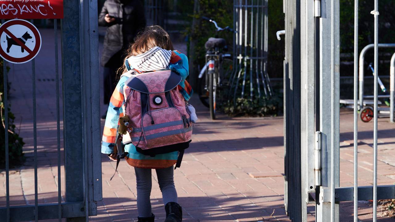 Köln: Grundschulkind betritt mit Schulranzen das Gelände.