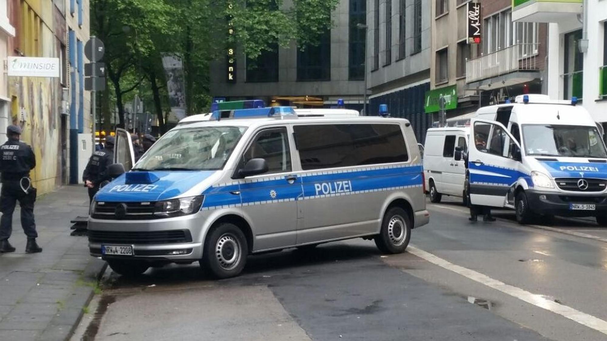 Zwei Polizeifahrzeuge stehen auf der Straße, eins quer.