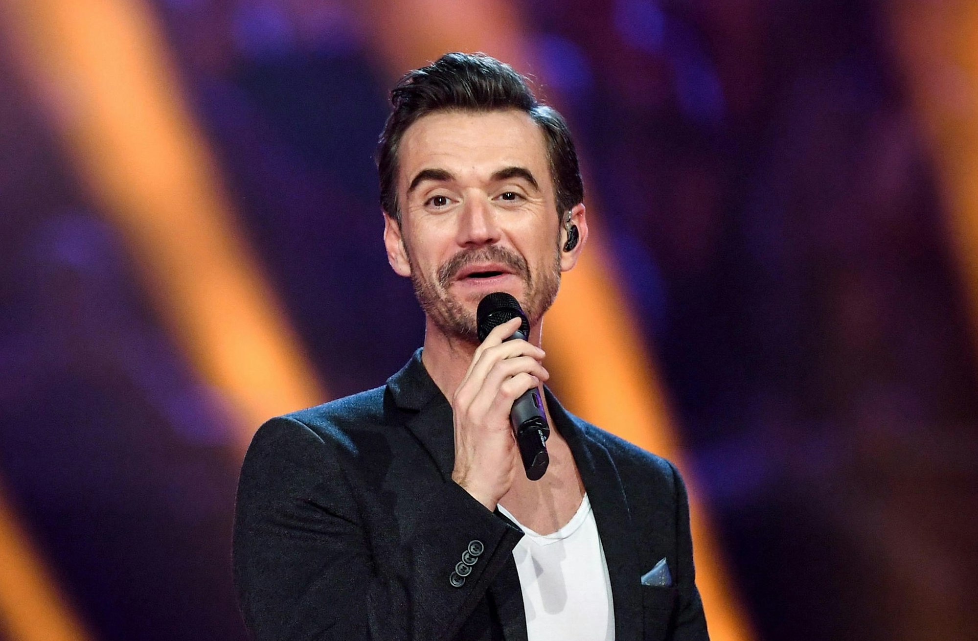 Florian Silbereisen steht bei „Schlagerchampions, das große Fest der Besten” mit Mikrofon auf der Bühne.