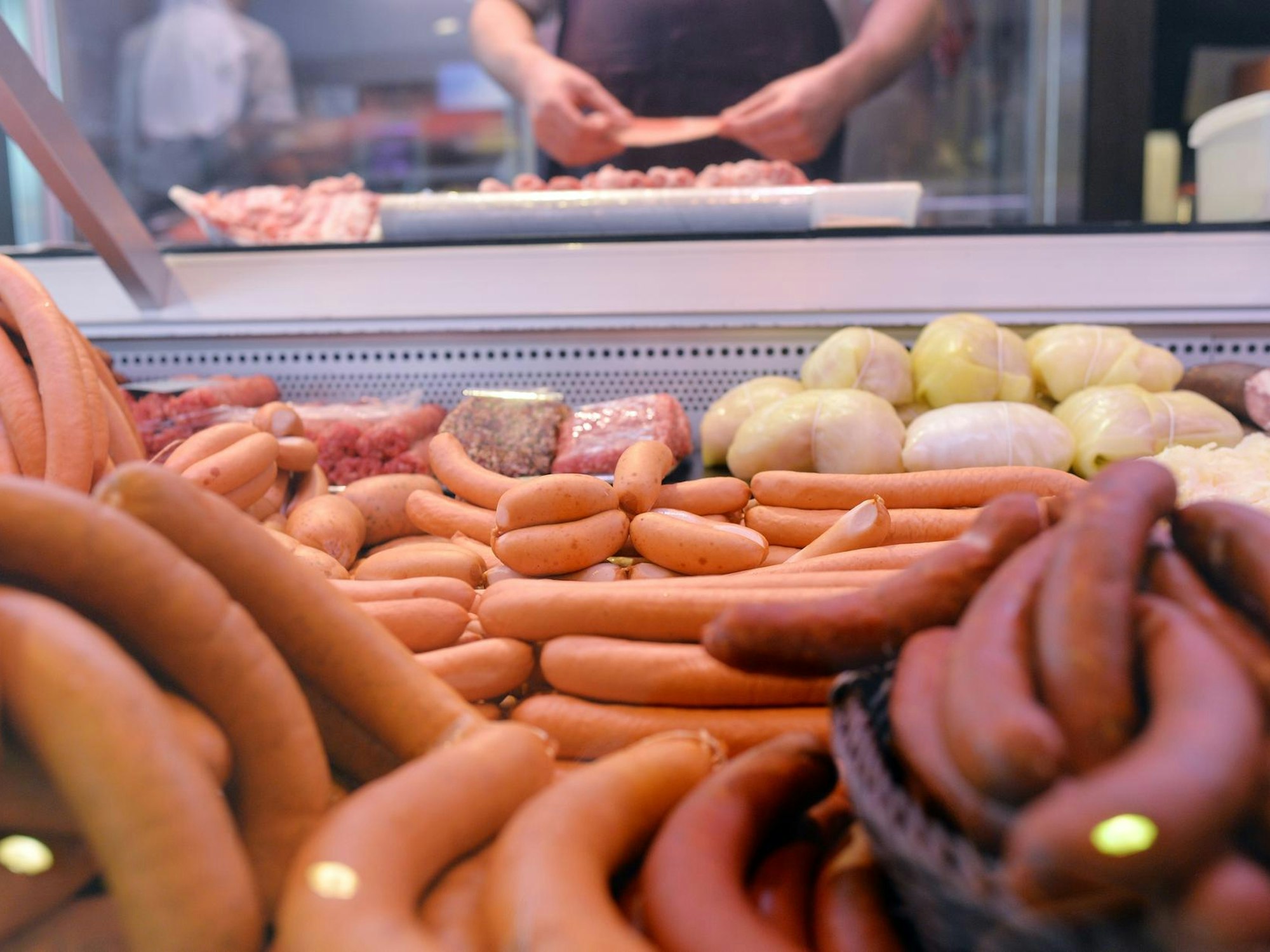 Fleischprodukte liegen in der Auslage einer Metzgerei.