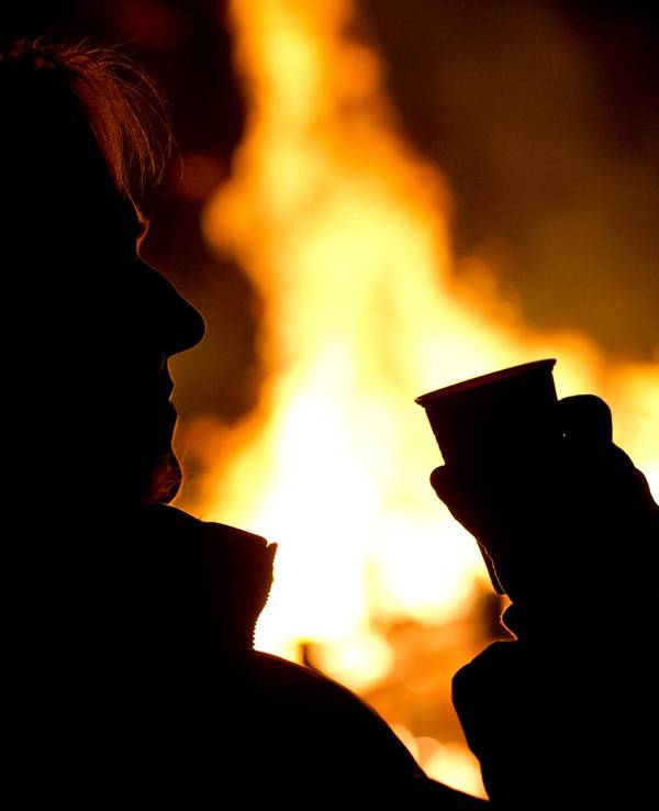 Die Silhouette eines Menschen setzt sich auf diesem undatierten Foto vor einem Feuer ab.