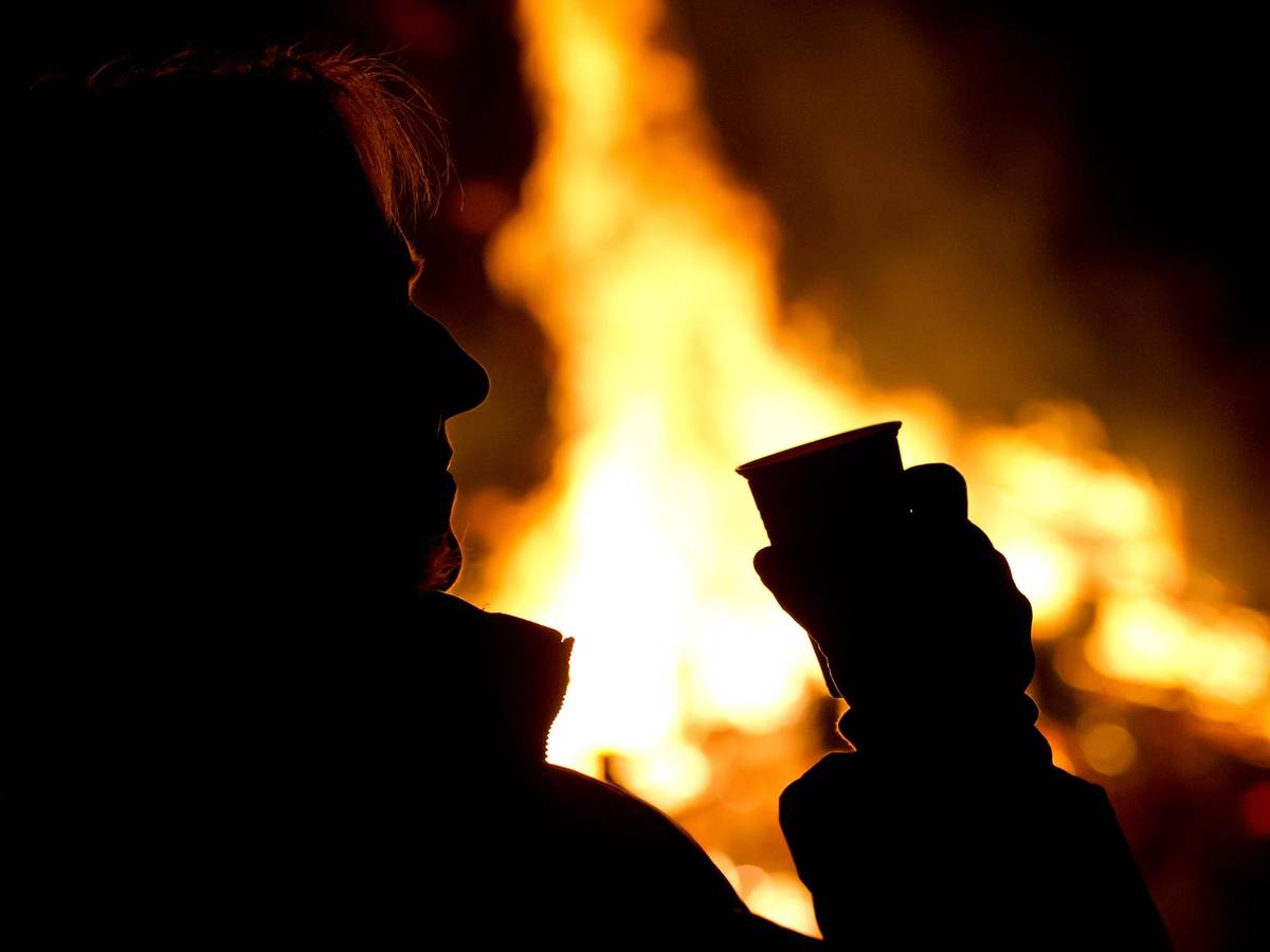 Die Silhouette eines Menschen setzt sich auf diesem undatierten Foto vor einem Feuer ab.