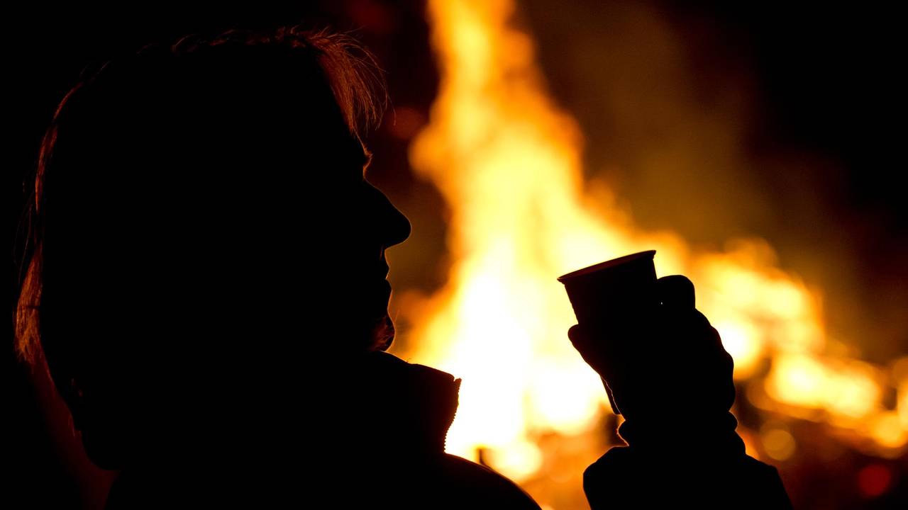Die Silhouette eines Menschen setzt sich auf diesem undatierten Foto vor einem Feuer ab.