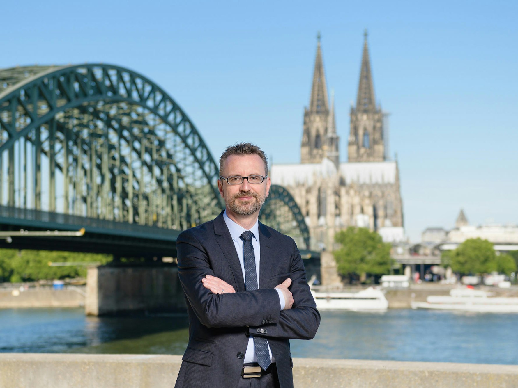KölnTourismus-Chef Jürgen Amann steht vor der Hohenzollernbrücke.