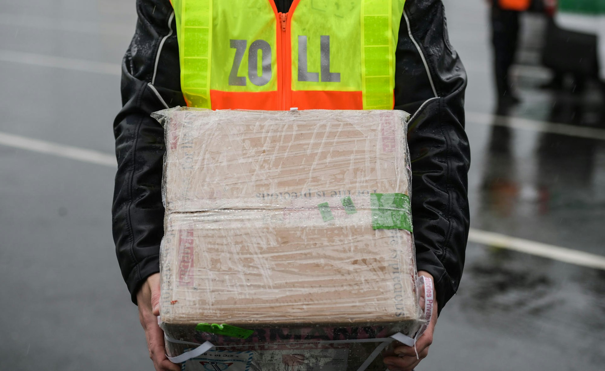 Ein Zollbeamter hält ein Paket.