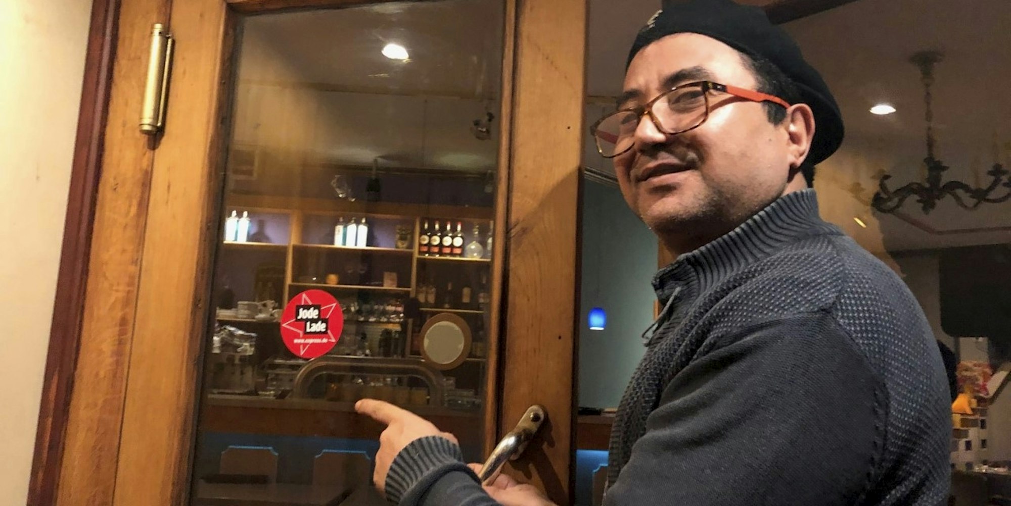 Inhaber Slim Chebbi bringt das Jode-Lade-Siegel am Roland Eck an.