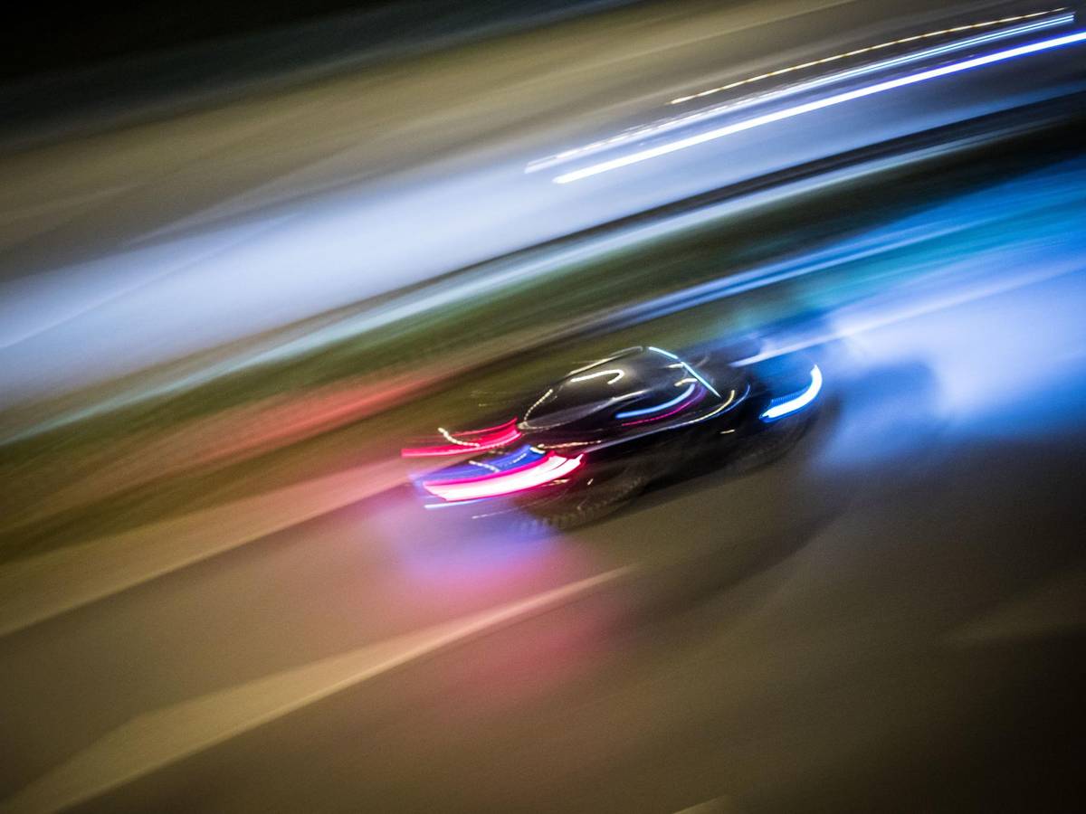 Ein Auto rast über eine Straße.