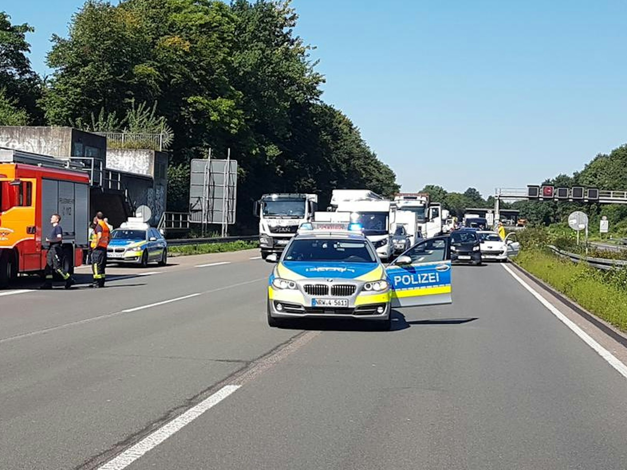 Ein Polizeifahrzeug steht mit geöffneter Tür auf einer Autobahn.