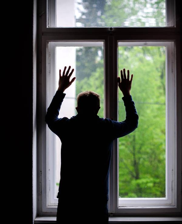 Ein Mann schaut aus einem Fenster.