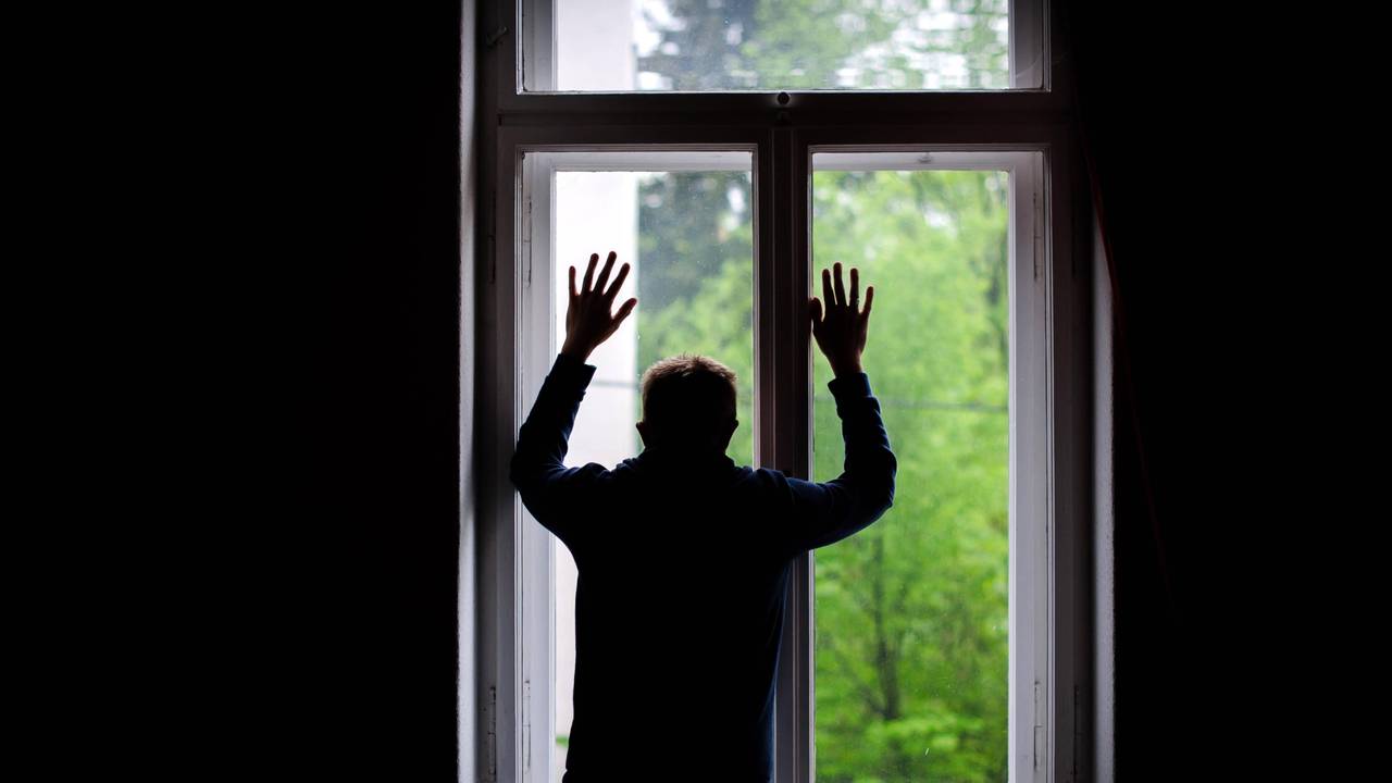 Ein Mann schaut aus einem Fenster.