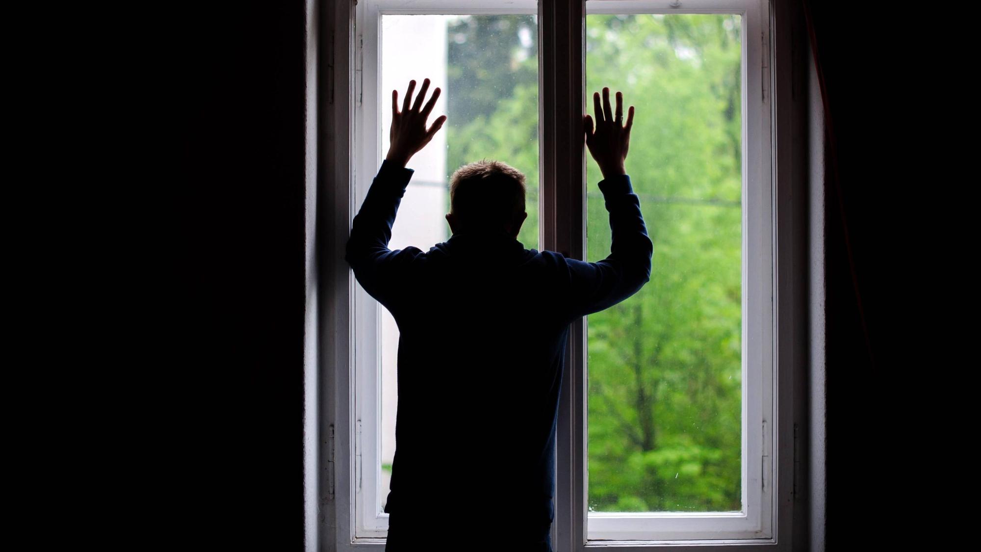 Ein Mann schaut aus einem Fenster.