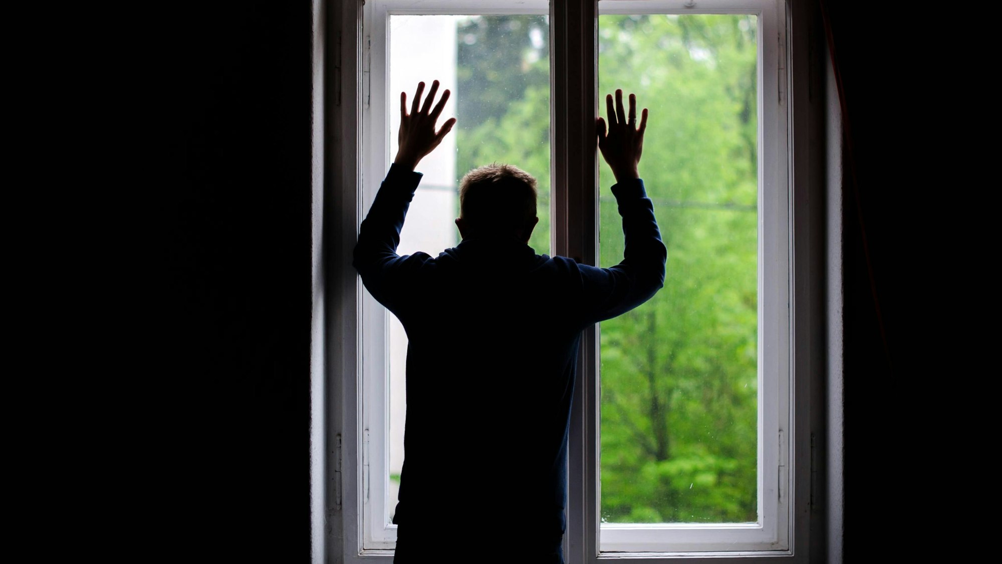 Ein Mann schaut aus einem Fenster.