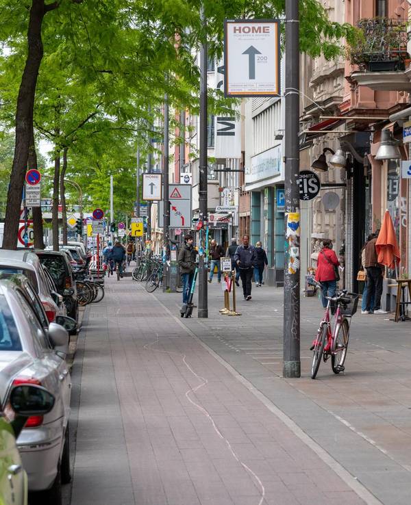 Passanten gehen auf der Aachener Straße in Köln.