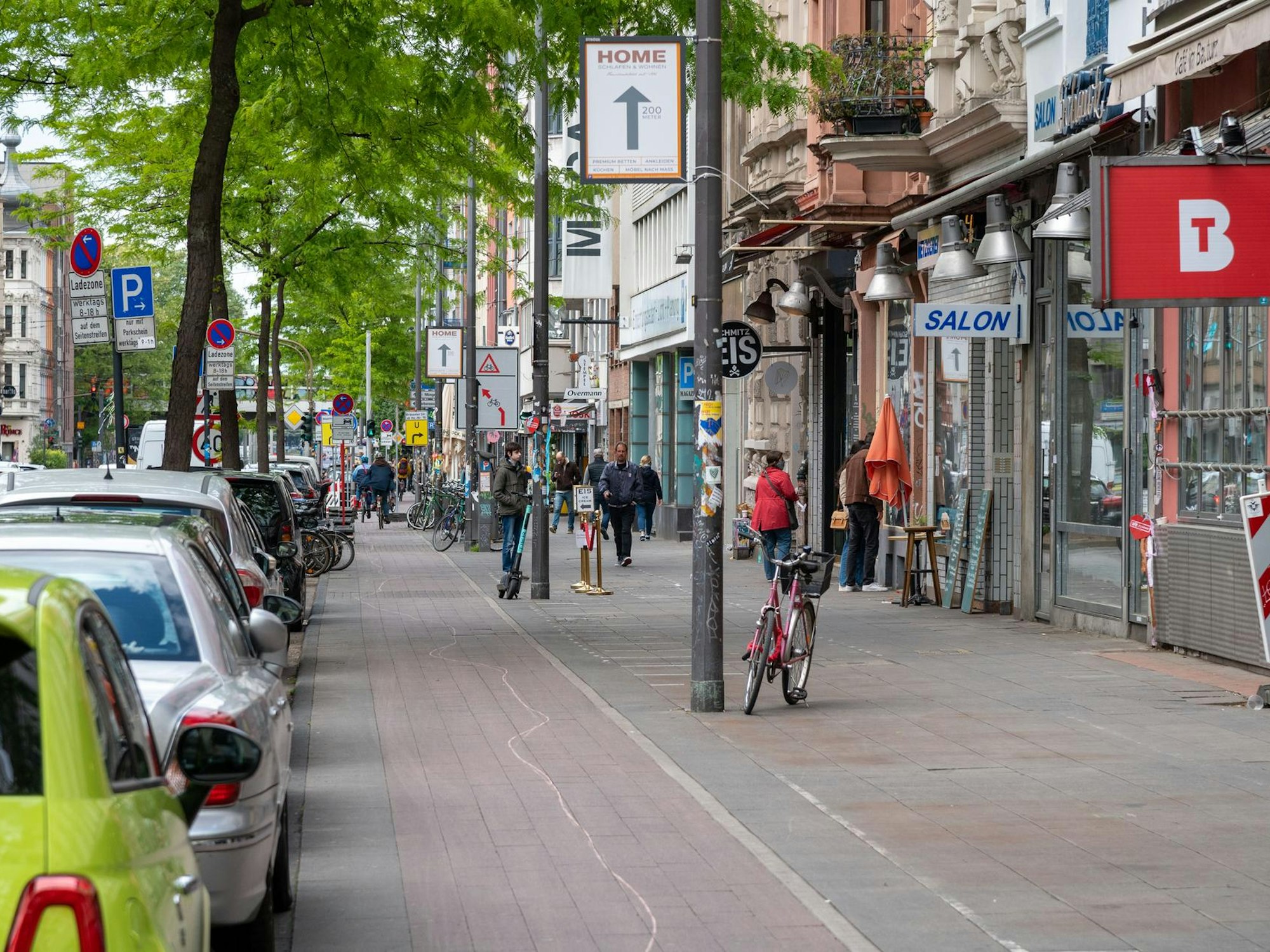 Passanten gehen auf der Aachener Straße in Köln.