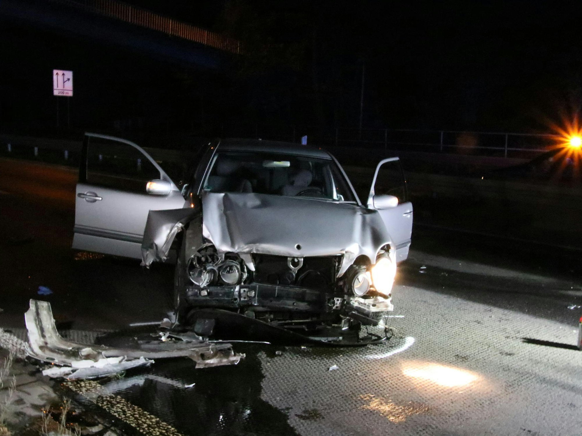 Ein zerstörtes Auto steht auf der Fahrbahn.