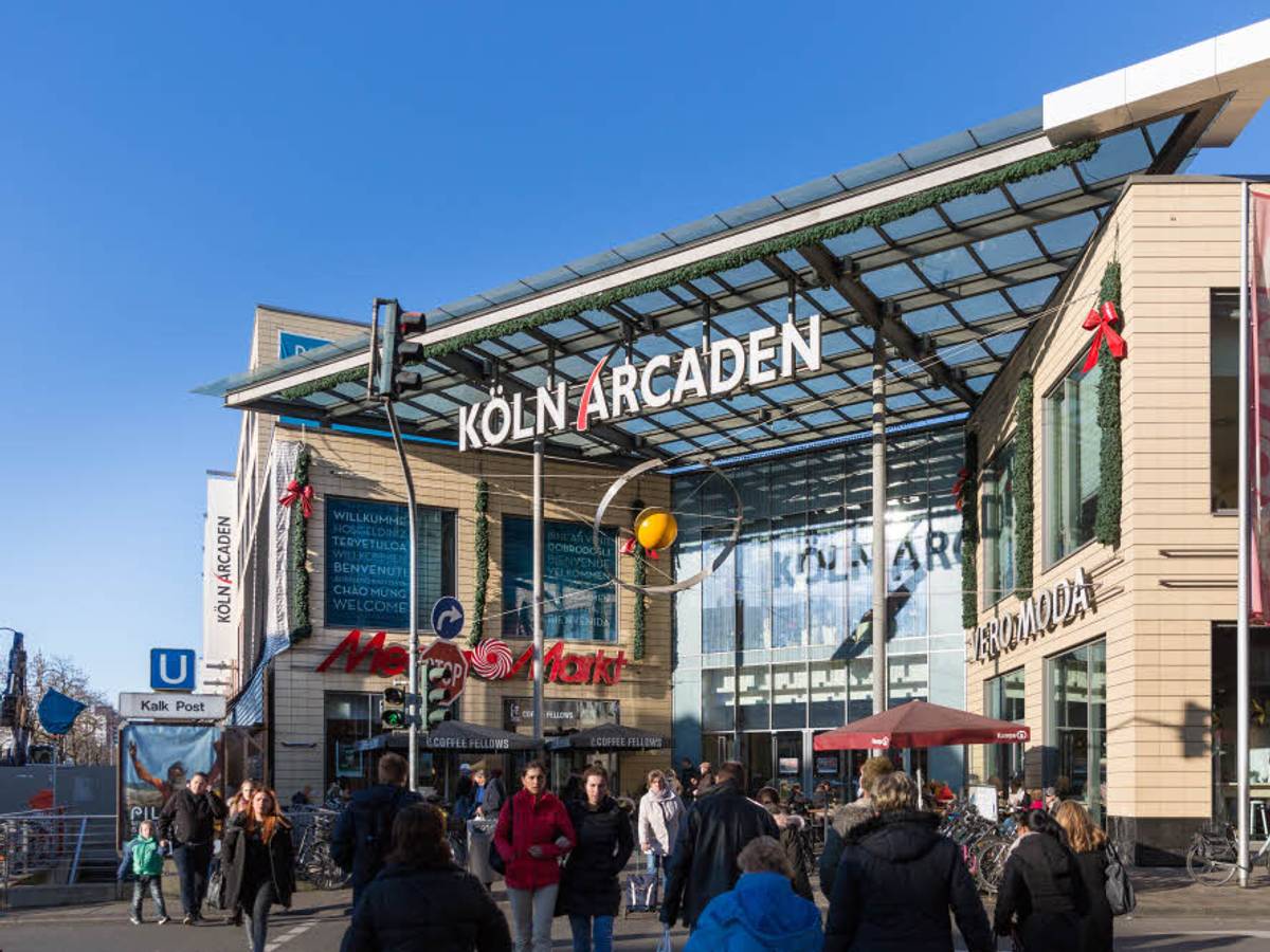 Menschen strömen auf den Eingang der Köln Arcaden zu.