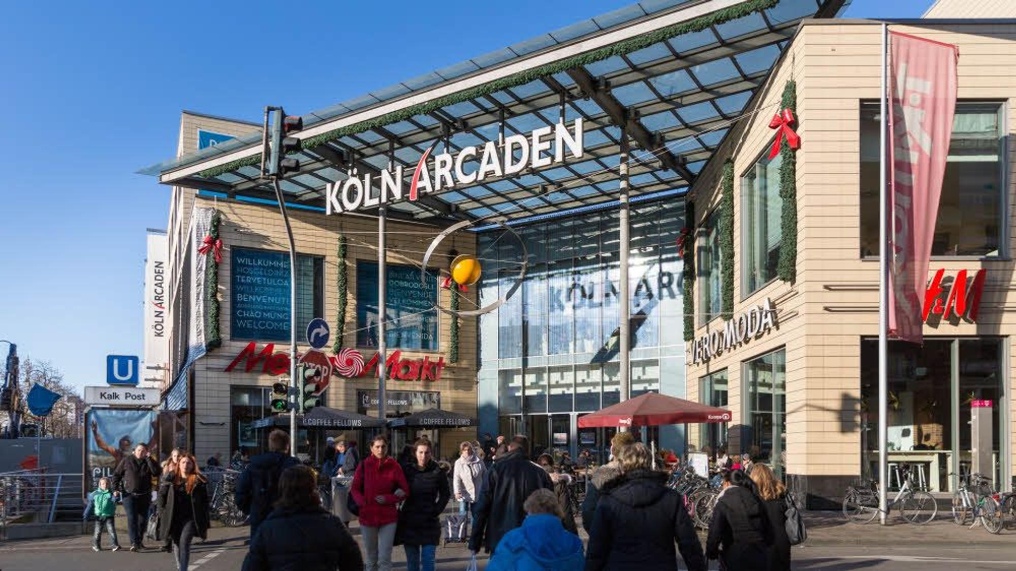 Menschen strömen auf das Einkaufszentrum „Köln Arcaden“ zu.